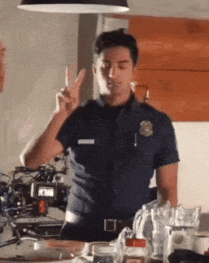 a man in a police uniform gives a peace sign