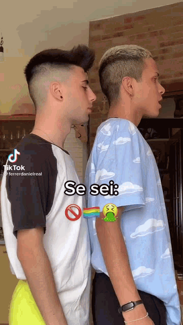 two young men are standing next to each other and one has a rainbow on his arm