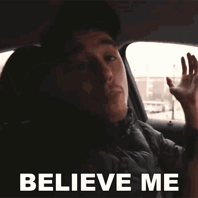 a man in a car says " believe me " in white letters