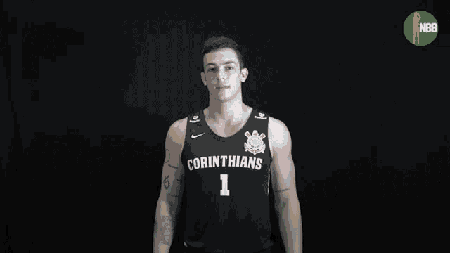 a man in a corinthians jersey smiles in front of a black background