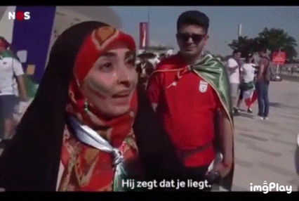 a man and a woman are standing next to each other in a crowd . the woman is wearing a hijab .