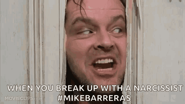 a man is looking through a hole in a door with his mouth open .