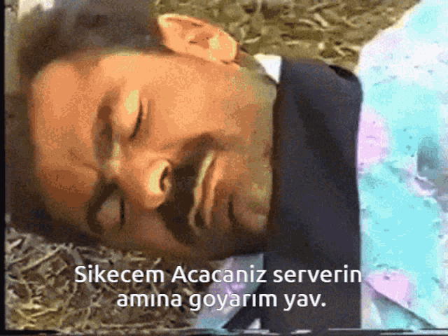 a man in a suit is laying on the ground with the words " sikecem acacaniz serverin amina goyarim yav "