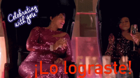 a woman in a pink sequined dress is holding a glass of champagne and celebrating with you