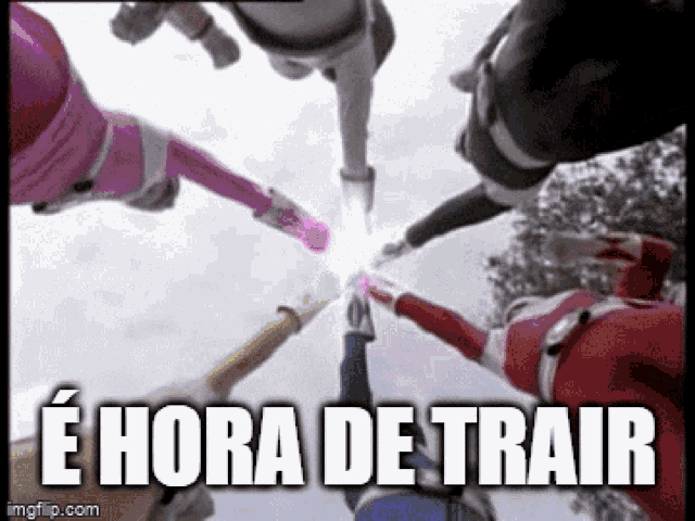 a group of power rangers are standing in a circle with their hands together .