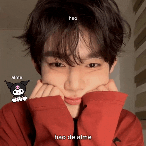 a boy in a red shirt has a sticker on his face that says " hao "