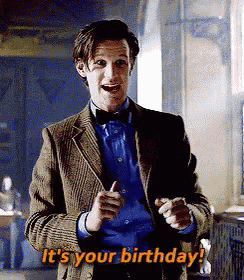 a man in a suit and bow tie is pointing at the camera and says it 's your birthday .