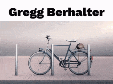 an advertisement for gregg berhalter shows a bicycle parked on a dock