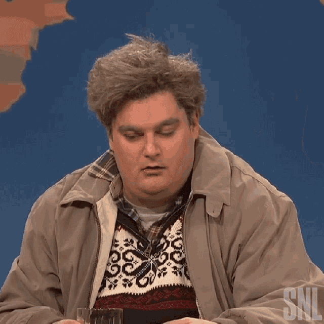 a man with his tongue out is wearing a sweater that says snl on it