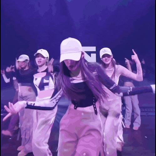 a group of young women are dancing in front of a sign that says ' n '