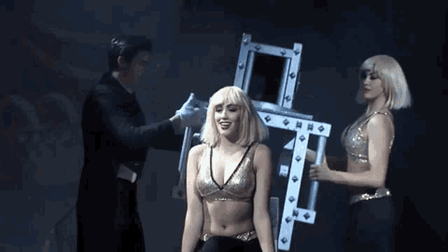 a woman in a gold top is being held by a man