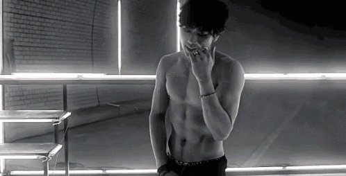a man without a shirt is smoking a cigarette