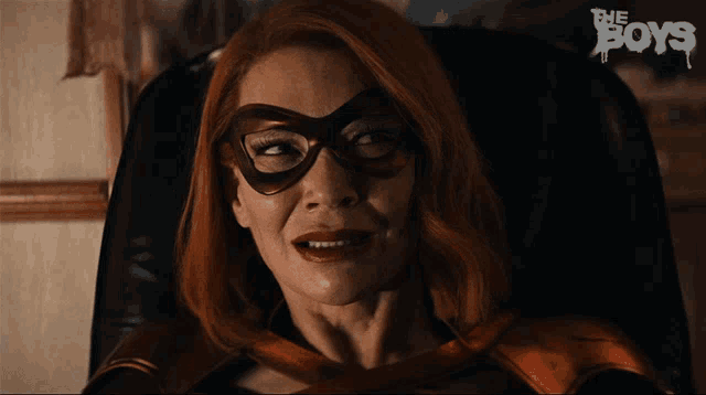 a woman in a superhero costume is sitting in a chair with the boys written on the bottom