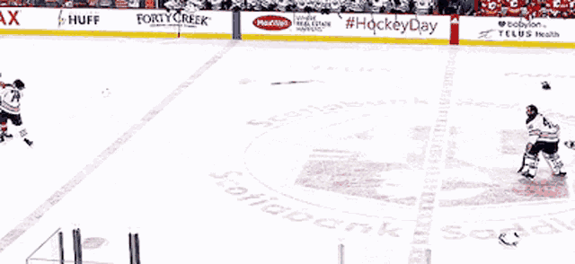 a hockey game is being played in a stadium with advertisements for huff and telus