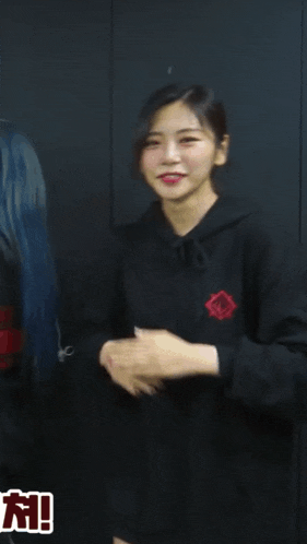 a woman in a black hoodie with a red rose on the front