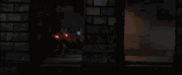 a dark room with a red light coming out of the door