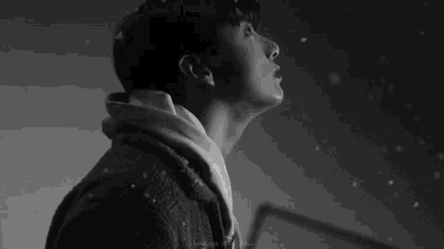 a black and white photo of jung kook with a man behind him