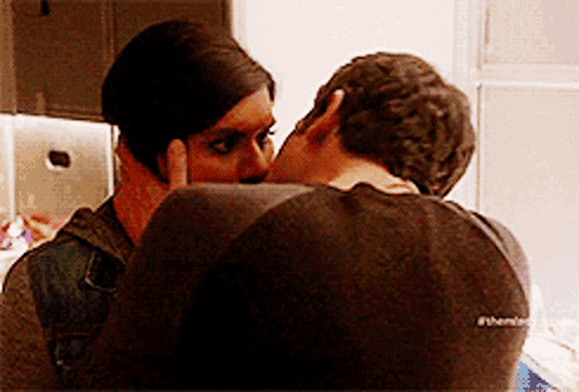 a man and a woman are kissing and the man is wearing a black shirt that says #themisfit