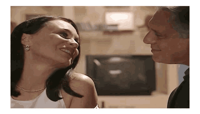 a man and a woman looking at each other and smiling