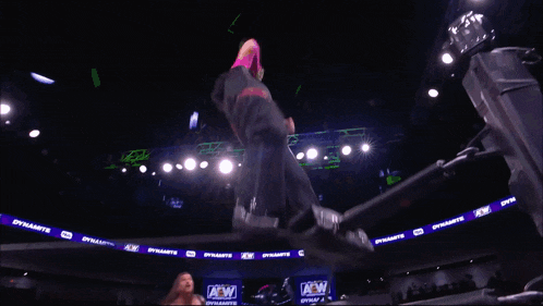 a wrestler is being lifted in the air by another wrestler in a ring that says dynamite on it