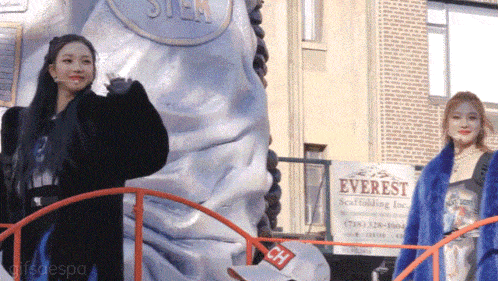 two women standing in front of a sign that says everest scaffolding inc