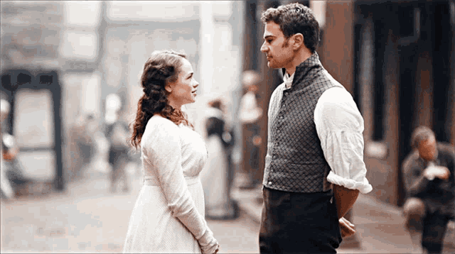 a man and a woman standing next to each other on a street