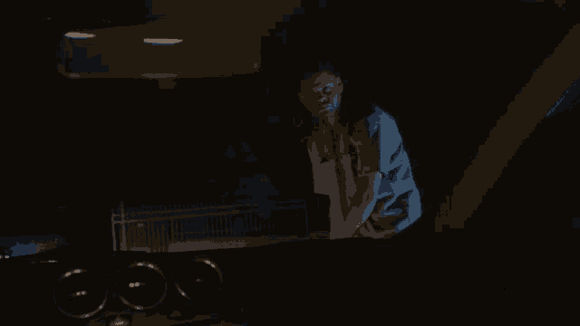 a man is standing in a dark room in front of a rear view mirror