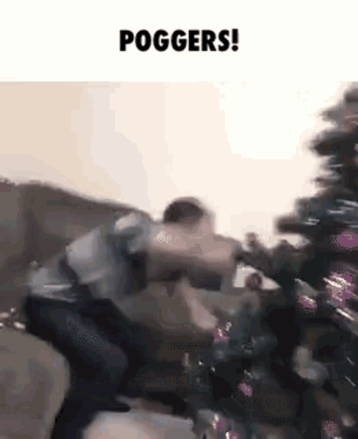 a man is sitting on a couch next to a christmas tree and holding a gun .
