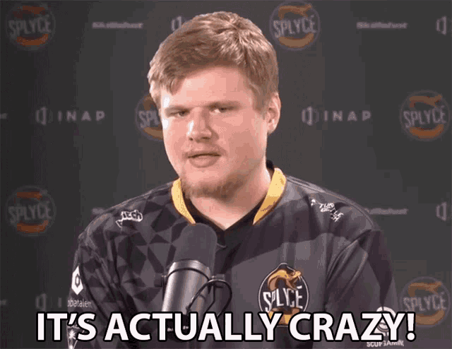 a man in a splyce jersey is talking into a microphone and says it 's actually crazy