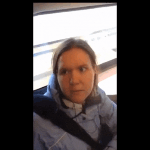 a woman wearing headphones is sitting in a car seat