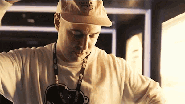 a man wearing a hat and a shirt with a lanyard around his neck that says ' hot topic '