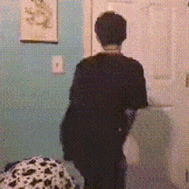a person in a black shirt is standing in a doorway