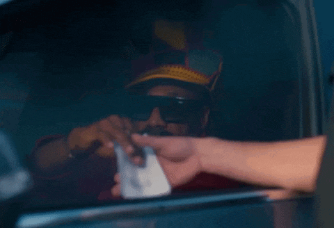 a man wearing sunglasses and a hat is handing a receipt to another man