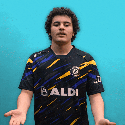 a man wearing a black and yellow shirt that says aldi