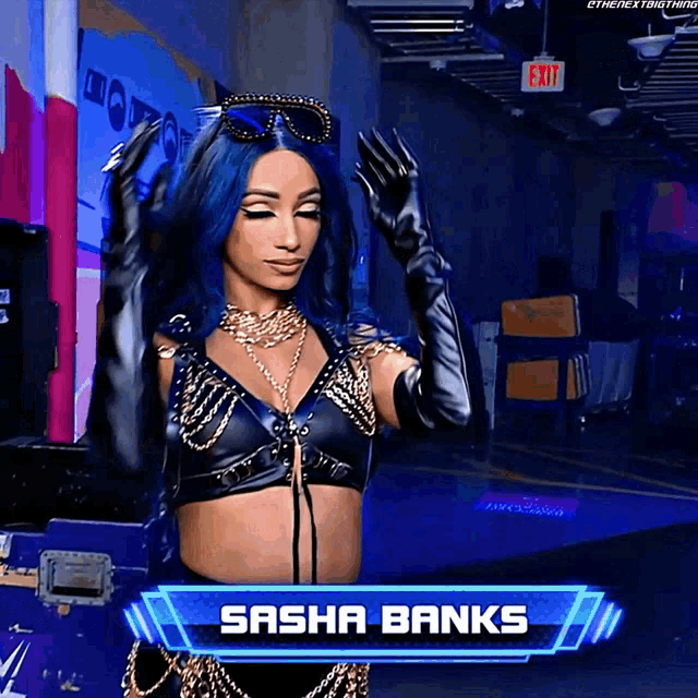 a female wrestler named sasha banks is standing in a dark room