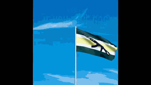 a flag with a gun on it is flying in a blue sky