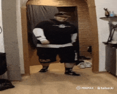 a man wearing a black shirt and shorts is dancing in a hallway
