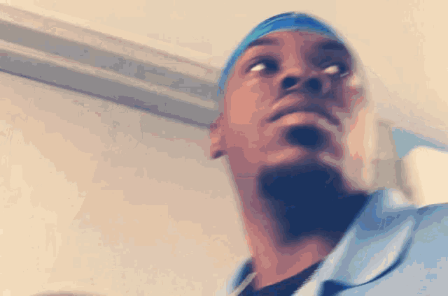 a man wearing a blue headband is looking up