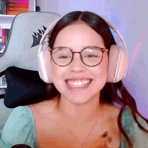 a woman wearing headphones and glasses is smiling