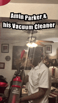a man is using a vacuum cleaner in a living room with the caption amin parker & his vacuum cleaner