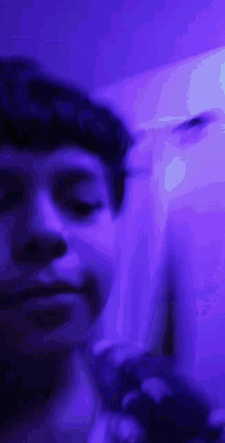 a close up of a person 's face with a purple background