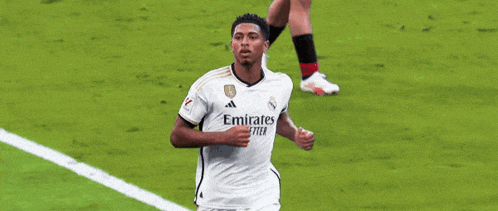a soccer player wearing a white emirates fly better shirt