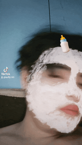 a person with a baby bottle on top of their head has a tiktok sticker on their face
