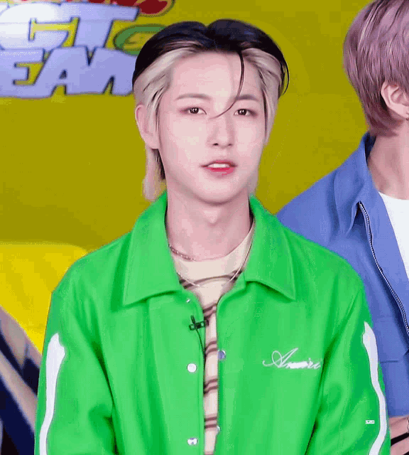a young man wearing a green jacket with the word amore on the back
