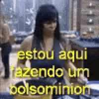 a woman is standing in a room with the words `` estou aqui fazendo um bolsominion '' written in yellow letters .