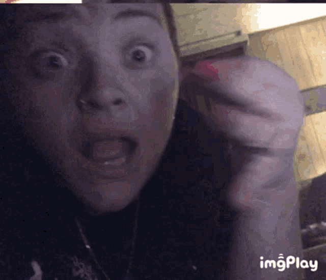 a close up of a woman 's face with the words imgplay at the bottom right