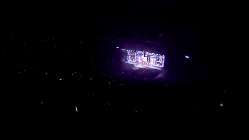 a stadium full of people watching a concert with a large screen that says ' a ' on it