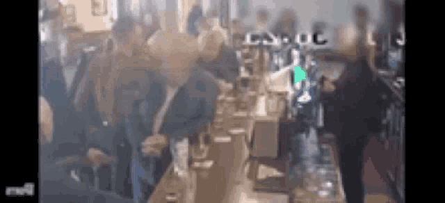 a group of people are standing around a bar in a pub .