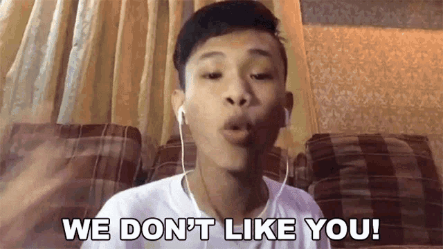 a young man wearing headphones says we don t like you