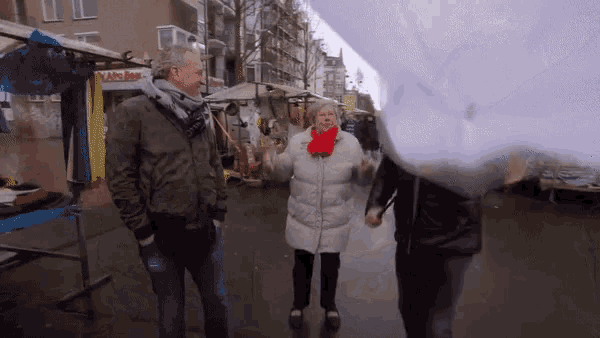 a man and a woman are walking down a street with cotton candy